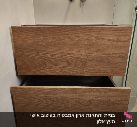ארון עץ עם מגירות פתוחות בחדר אמבטיה